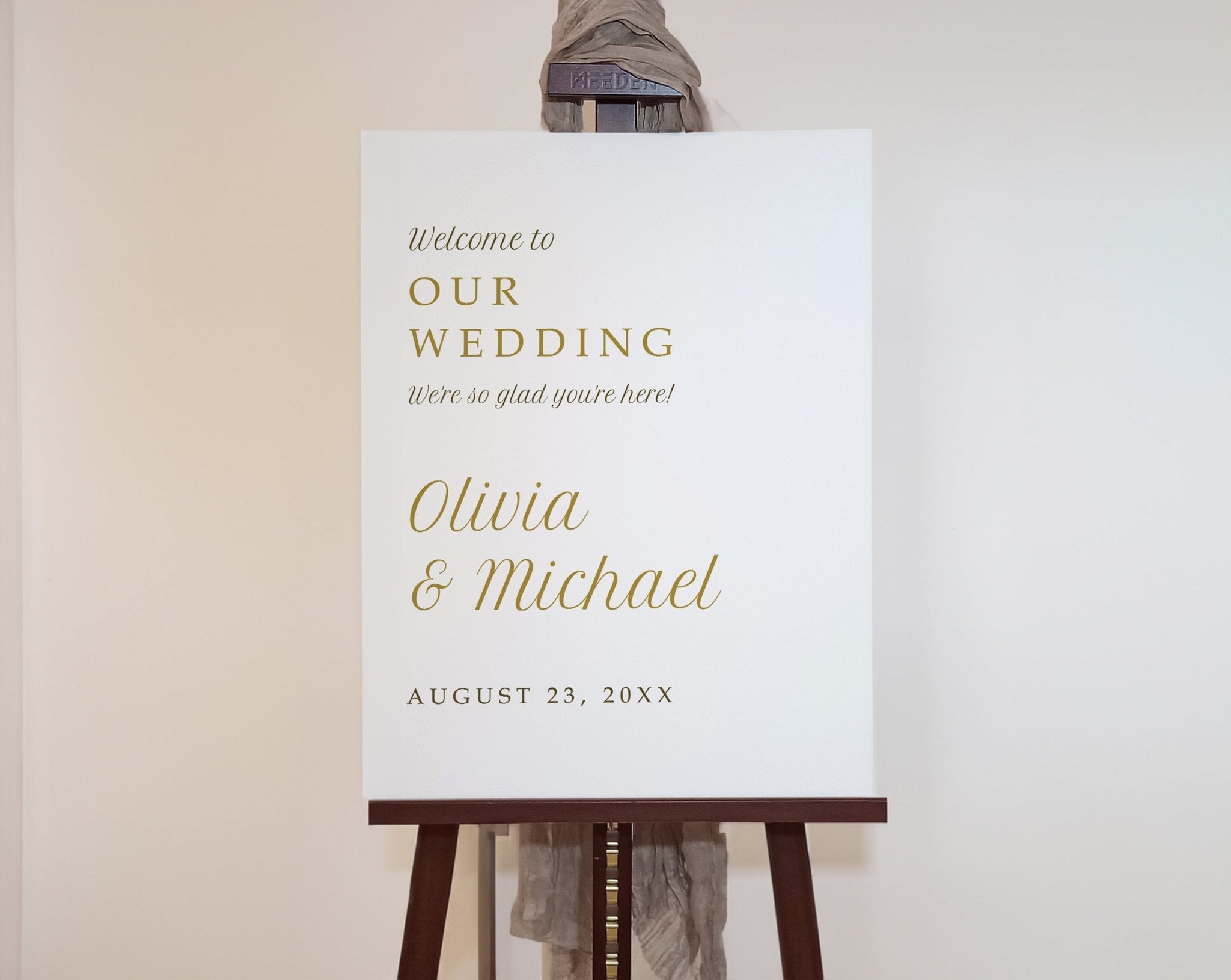 Wedding welcome sign on an easel with gold text on a white background