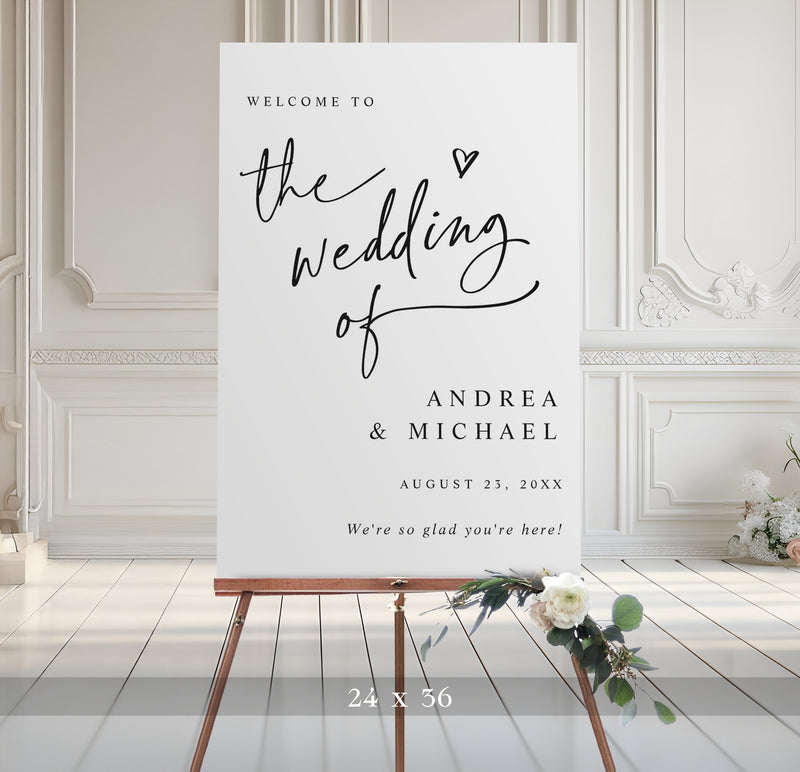 Modern black and white 24x36 wedding welcome sign with elegant handwritten script and small heart, personalized with couple’s names, wedding date, and the phrase “we’re so glad you’re here.”